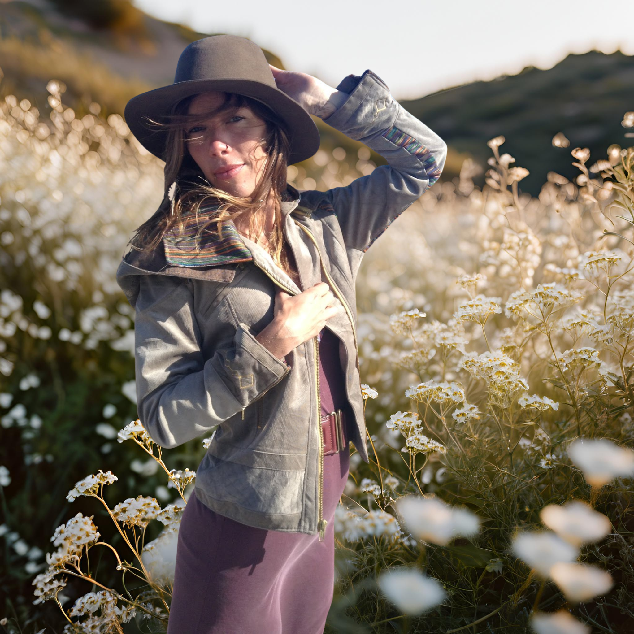 Woman in a hat and handmade biker jacket standing in a field of white flowers