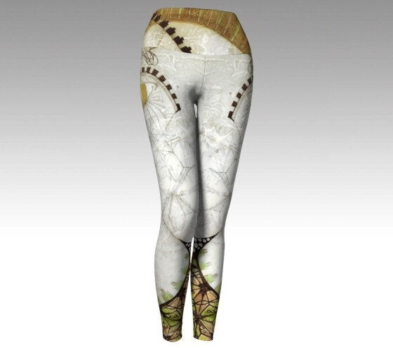 black and white and gold and green yoga leggings with cosmic and geometric designs on them