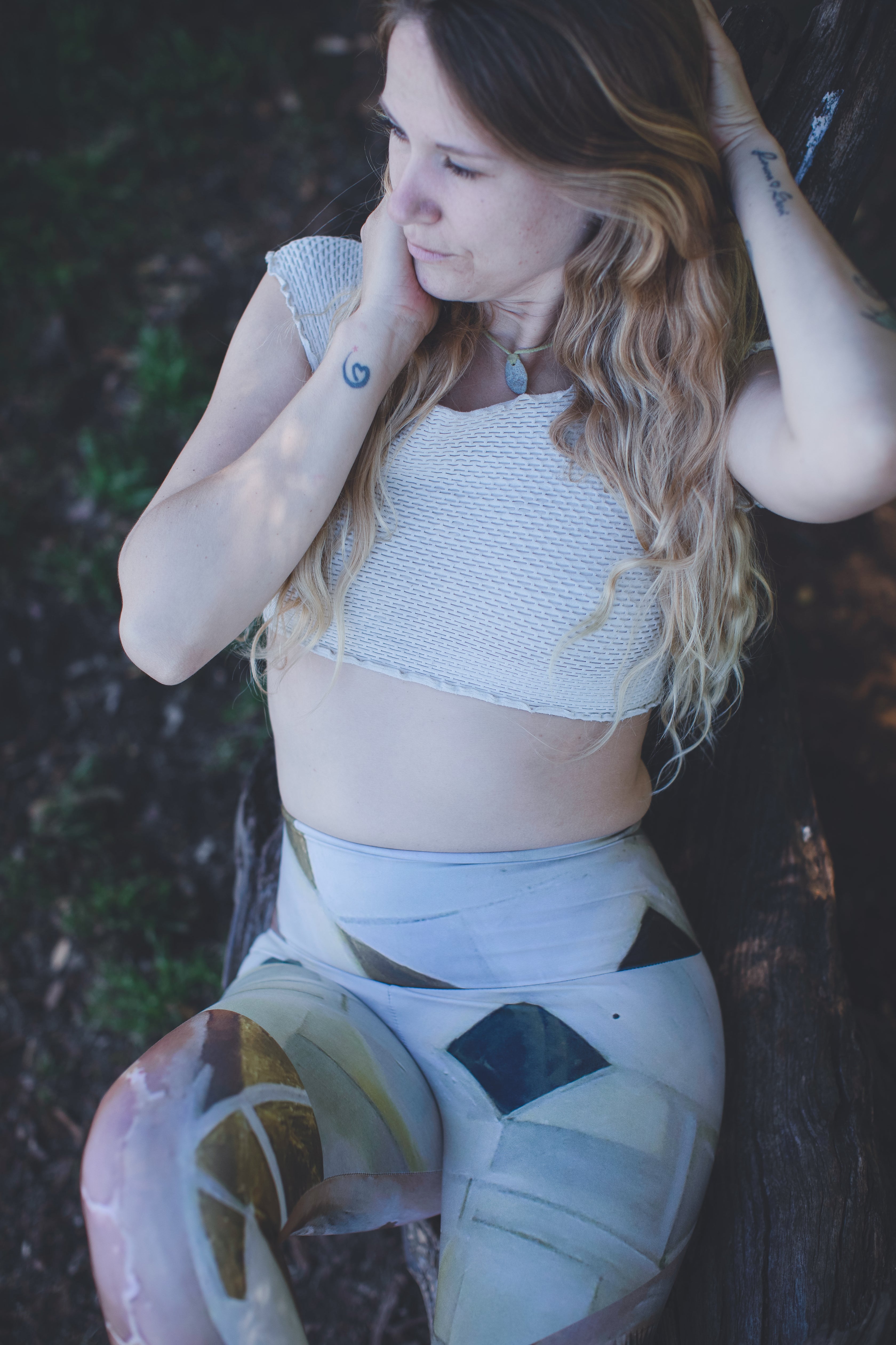 leggings featuring a geometric pattern with diamonds in gold, black, and white, and wide open eyes on the front.