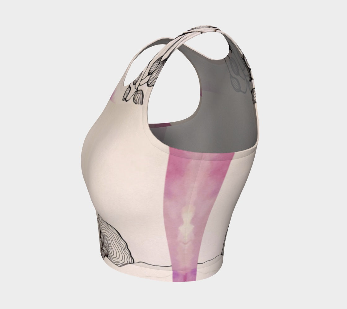 A beige yoga top with a floral and fungal design, featuring leaf patterns and what appears to be a stylized mushroom.