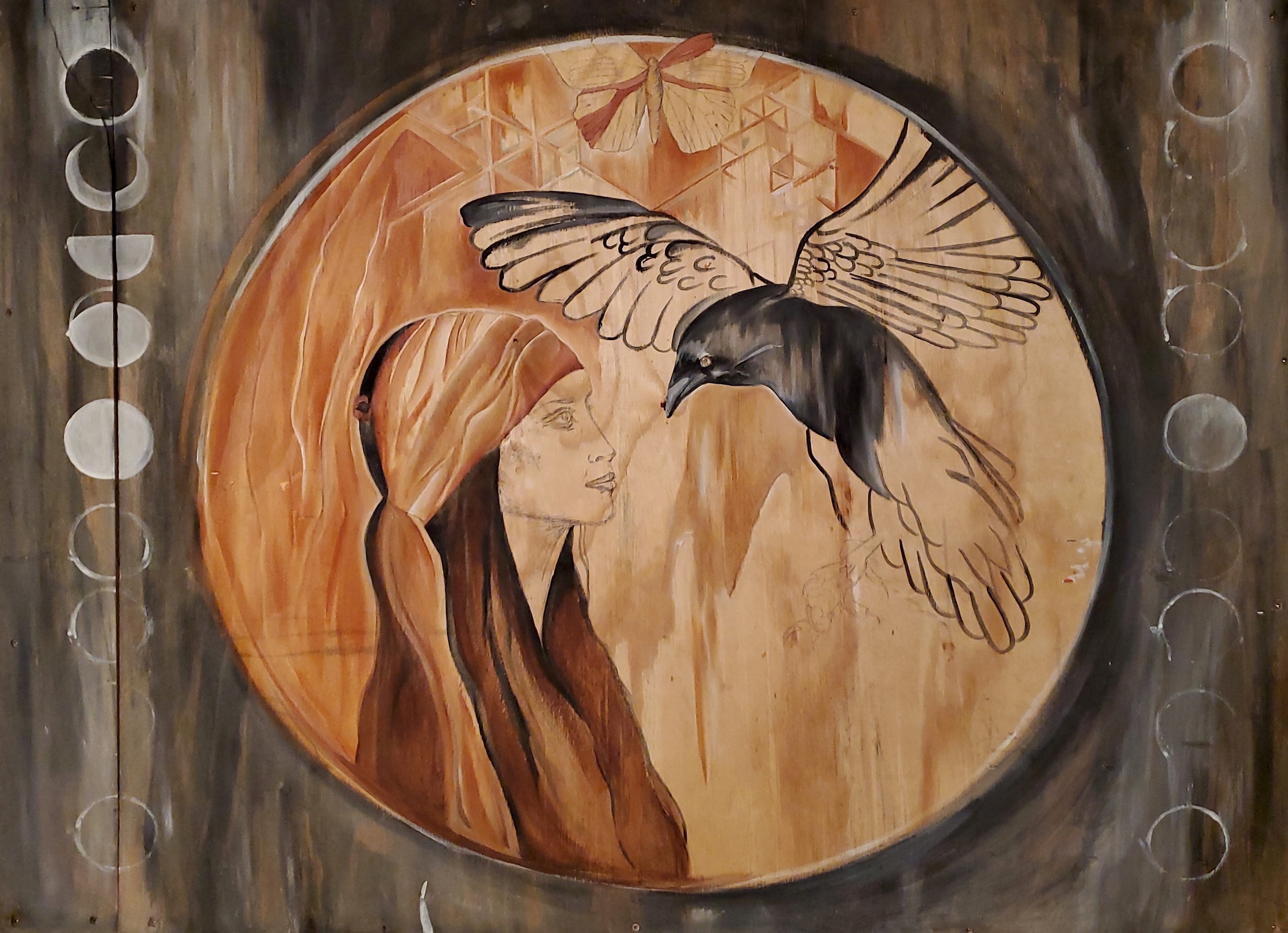 painting on reclaimed wood of a womans profile wearing a headband and facing a black raven with their wings open with a butterfly above them and moon phases on the sides