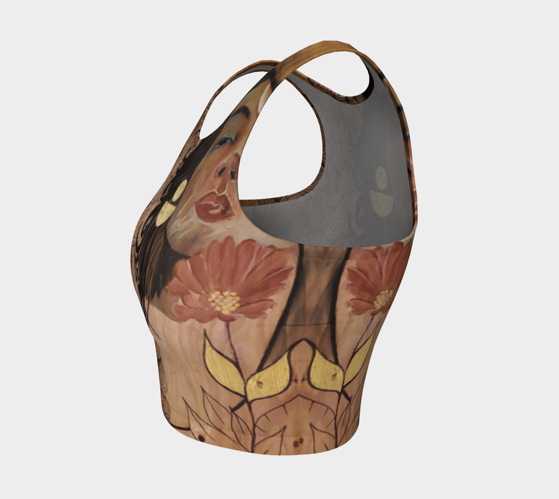 A yoga top with a floral and mushroom design, featuring a central goddess face illustration.