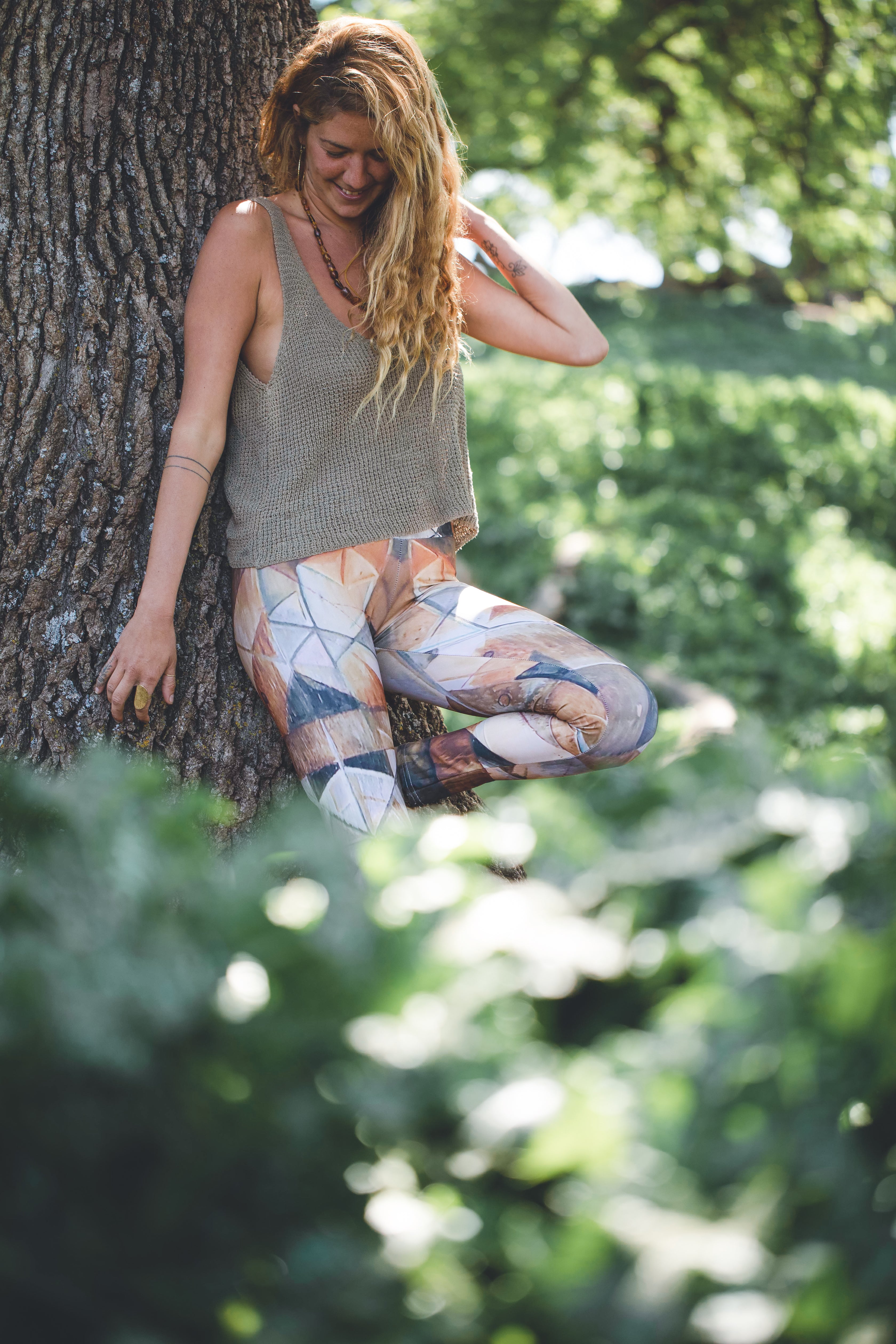 woman wearing Yoga leggings with geometric pattern on wood grain with lines in black brown and rust and green