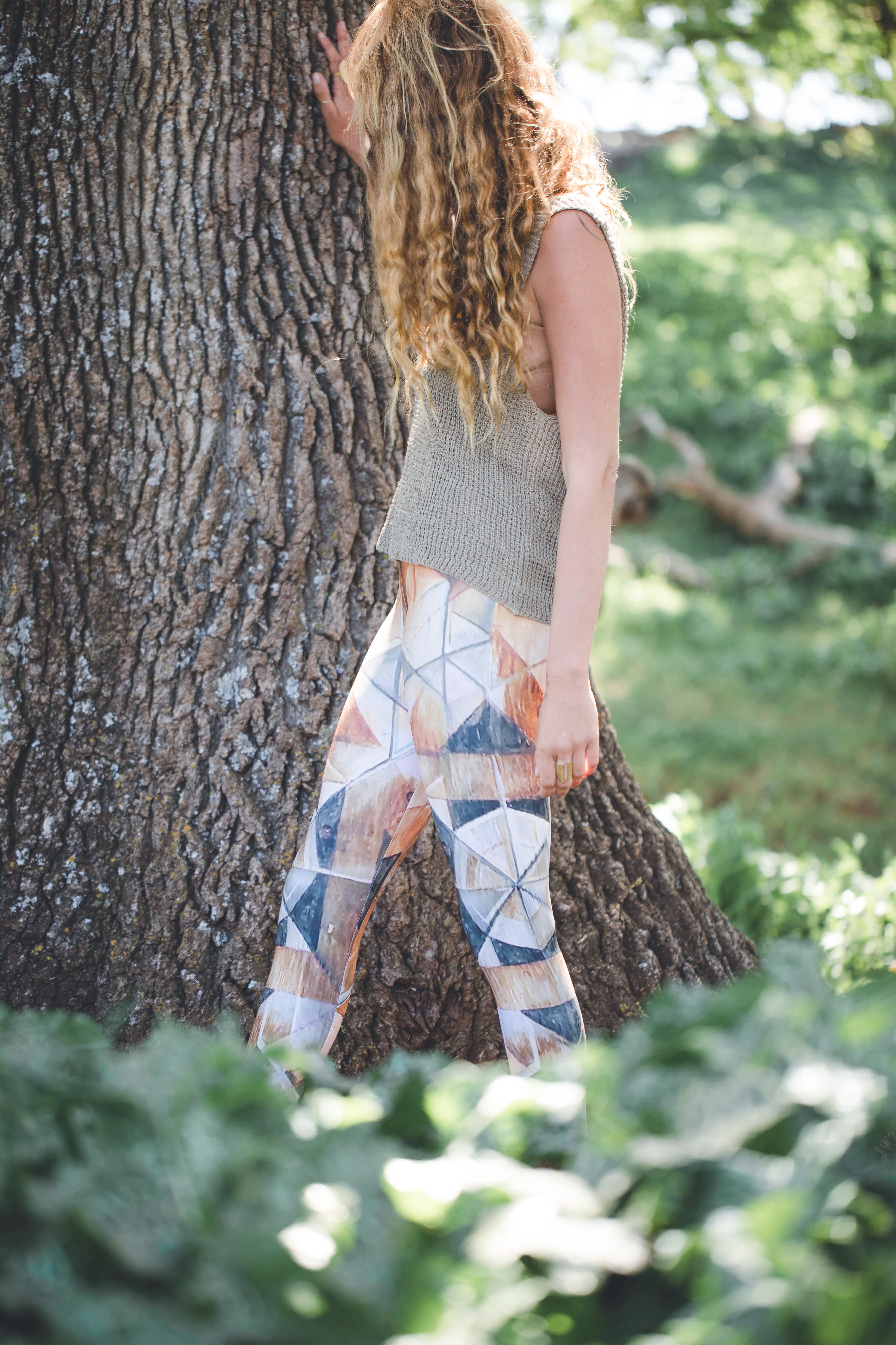 woman wearing Yoga leggings with geometric pattern on wood grain with lines in black brown and rust and green