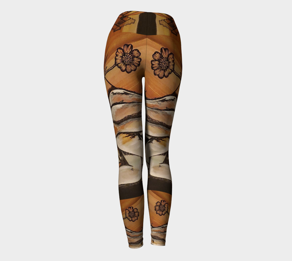 yoga leggings with a floral leaf line and crescent moon designs on a golden brown background.
