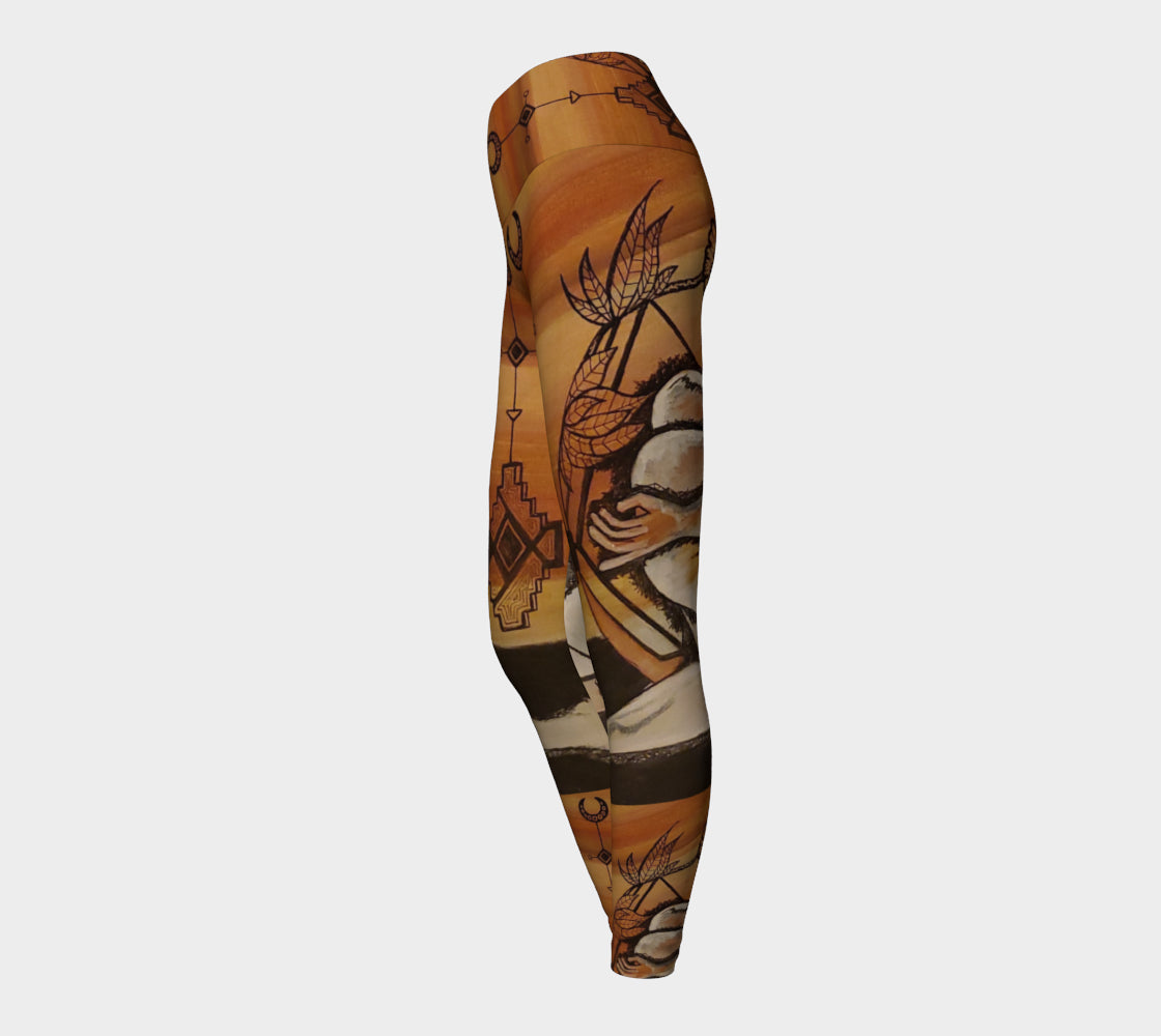 yoga leggings with a floral leaf line and crescent moon designs on a golden brown background.