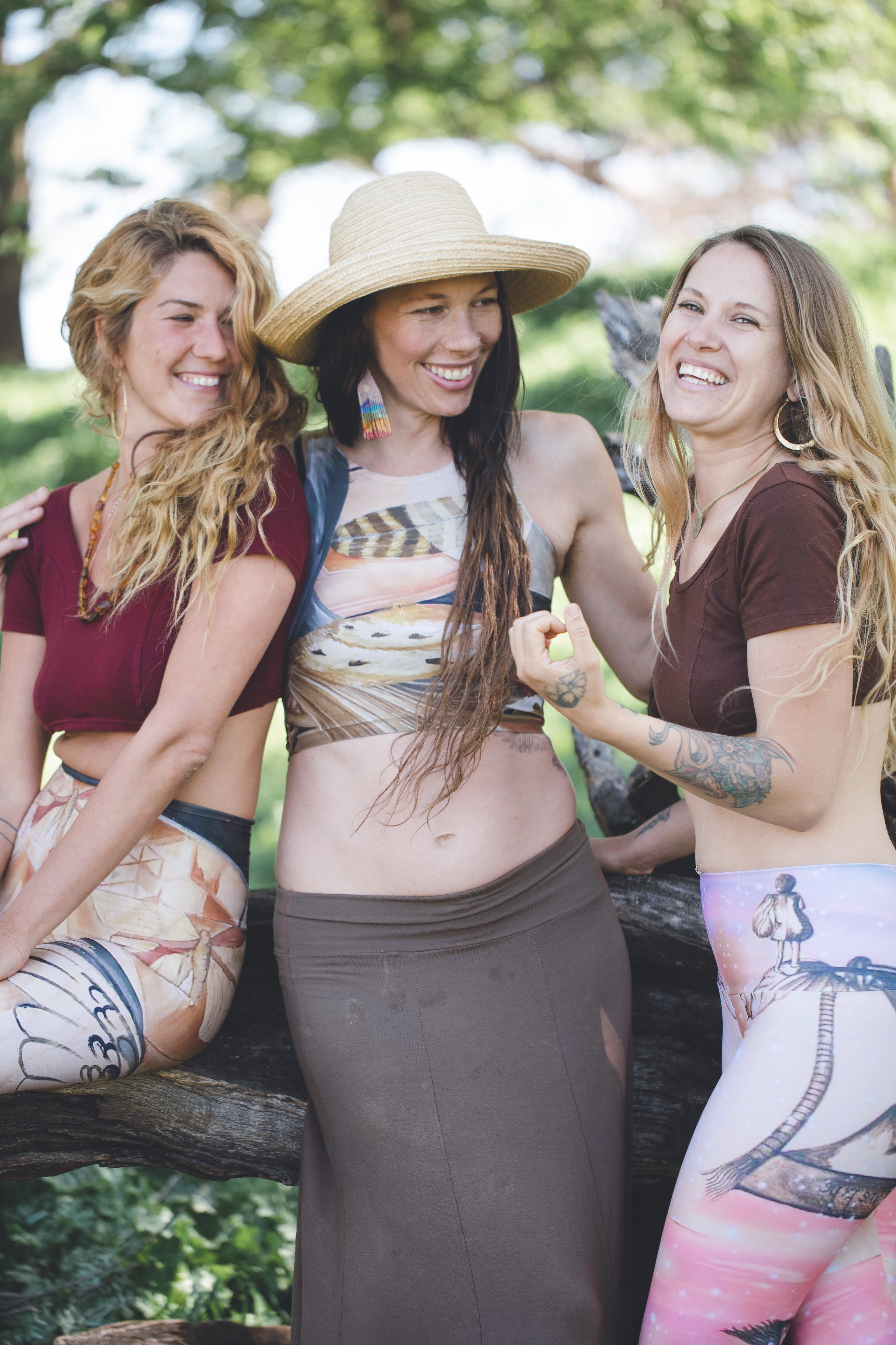 3 women wearing Yoga leggings in shades of pink and blue with a surreal pencil drawing of a little girl printed onto them