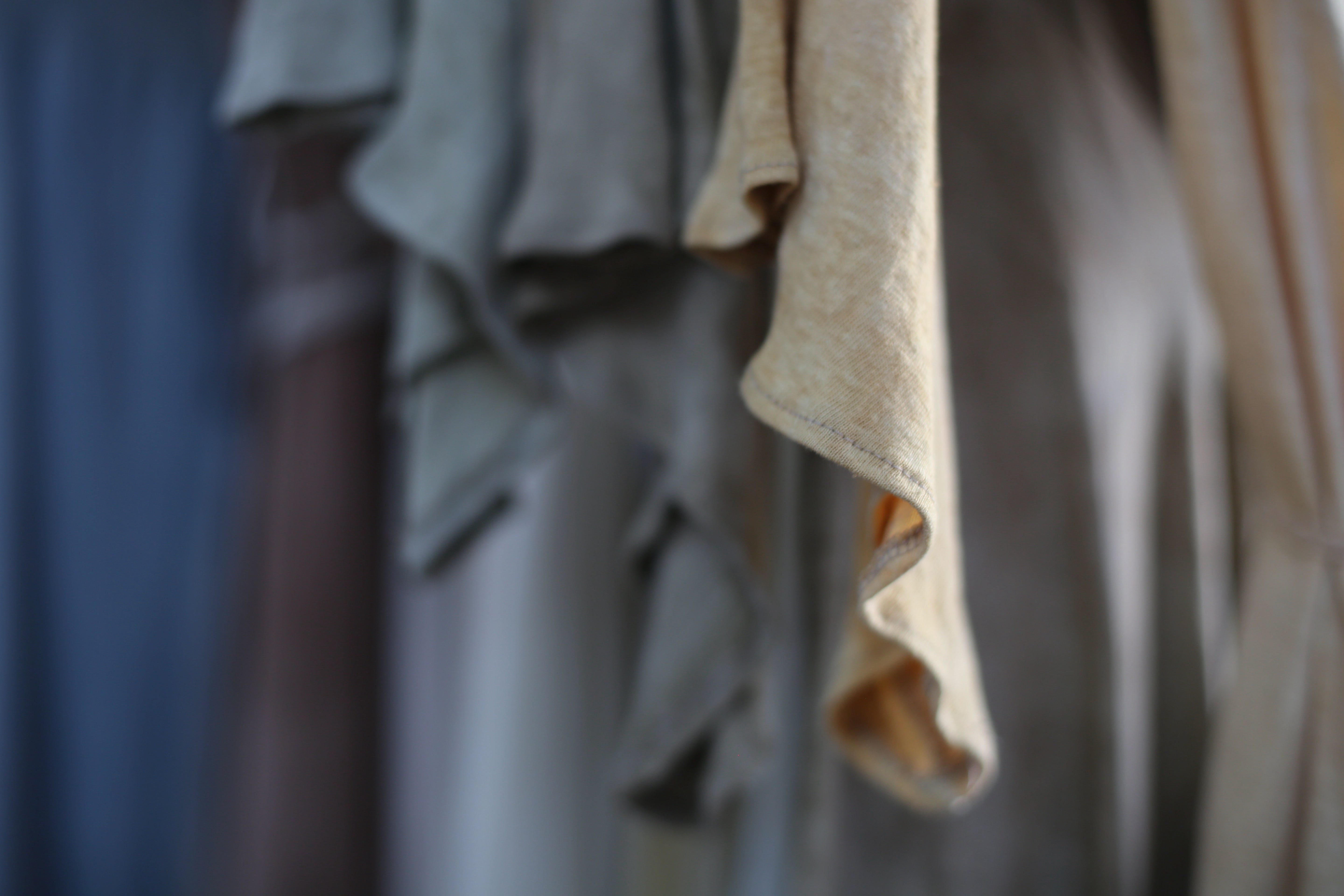 close up shot of a dress sleeve in shades of olive sage green with a rippled effect to the fabric
