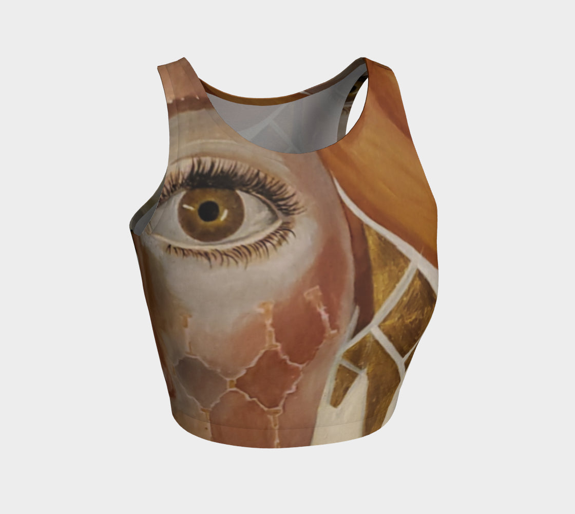 A crop top featuring a geometric pattern with diamonds in gold, black, and white, and wide open eyes on the front.