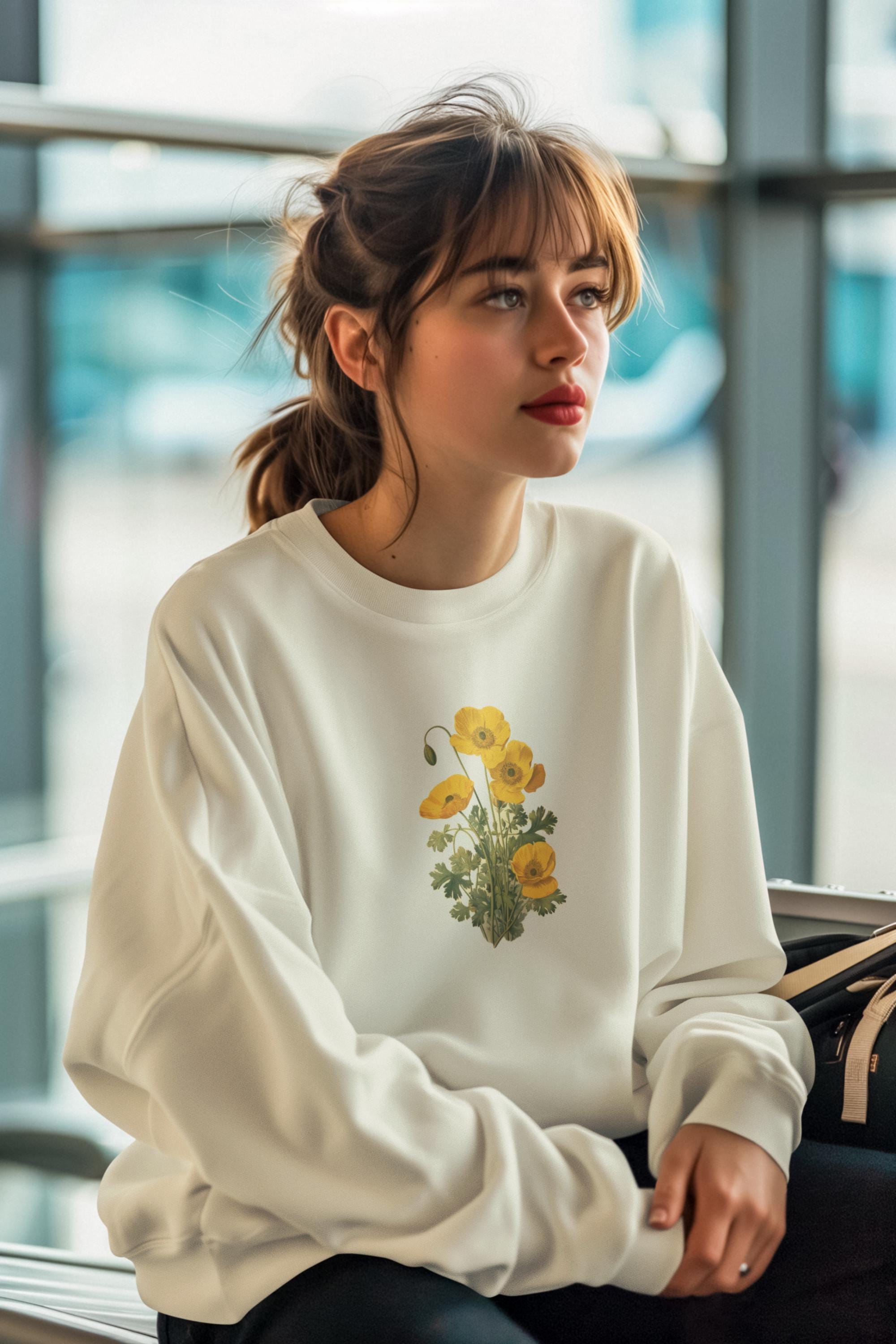 woman wearing a cream colored crewneck sweatshirt with yellow poppies on it