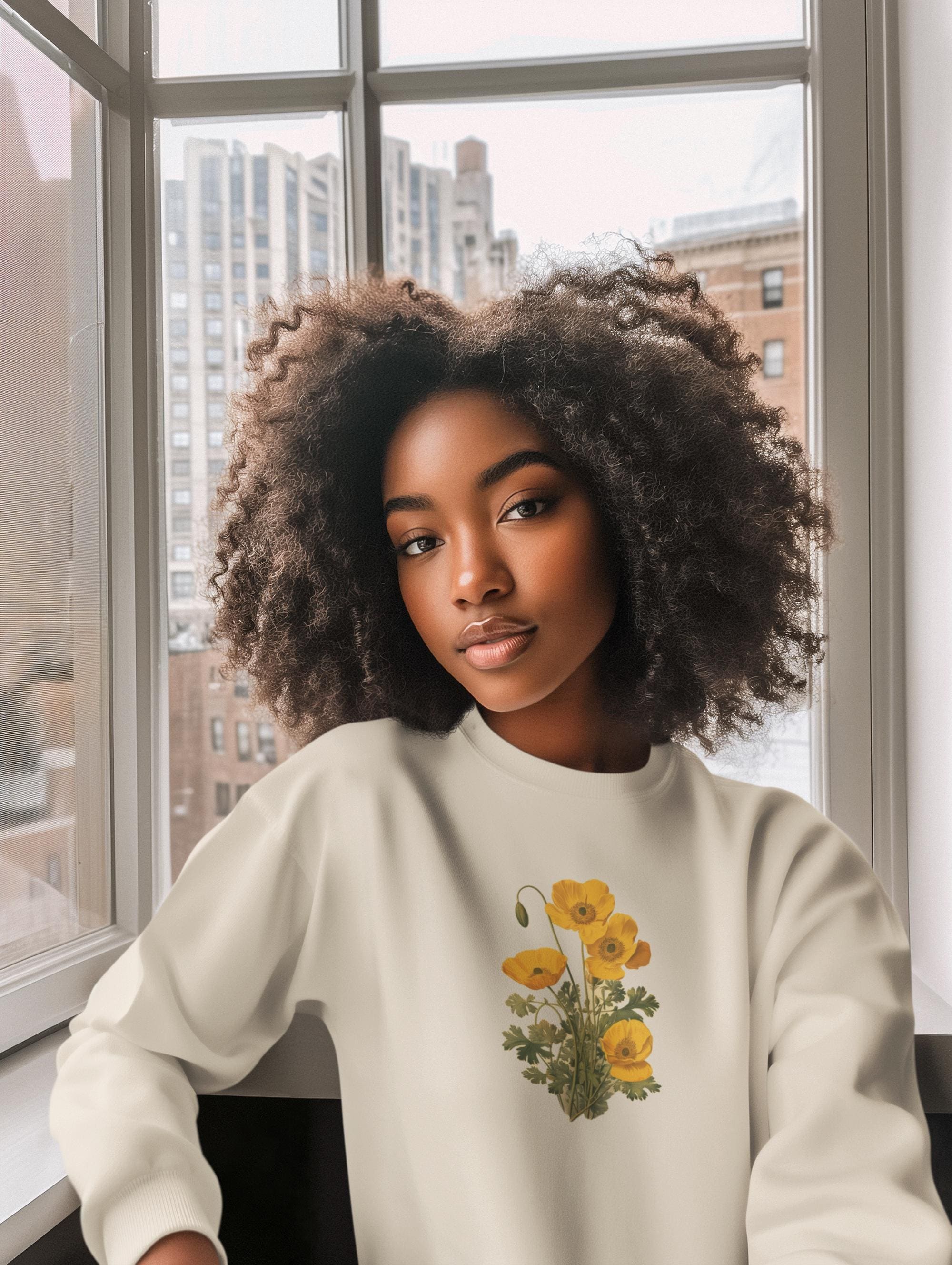 woman wearing a cream colored crewneck sweatshirt with yellow poppies on it