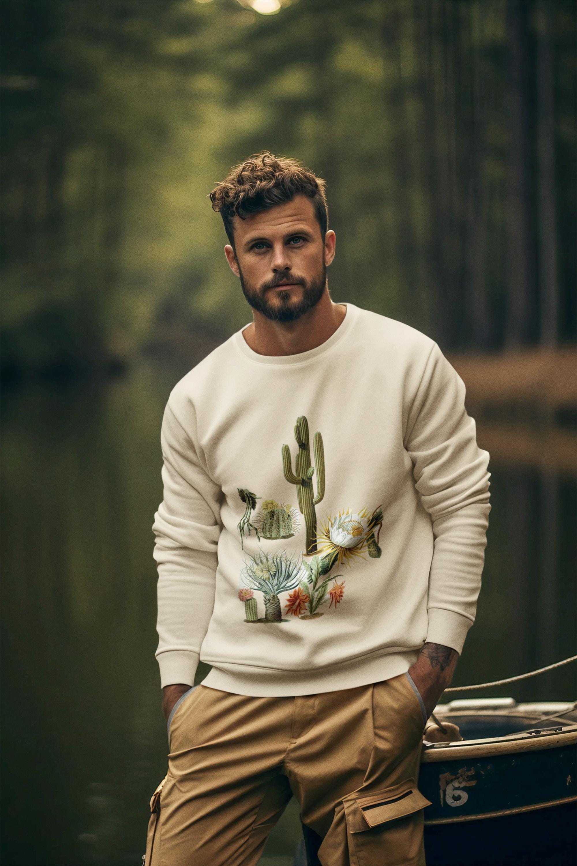 man wearing cream colored crew neck sweatshirt with cacti and blooms on it