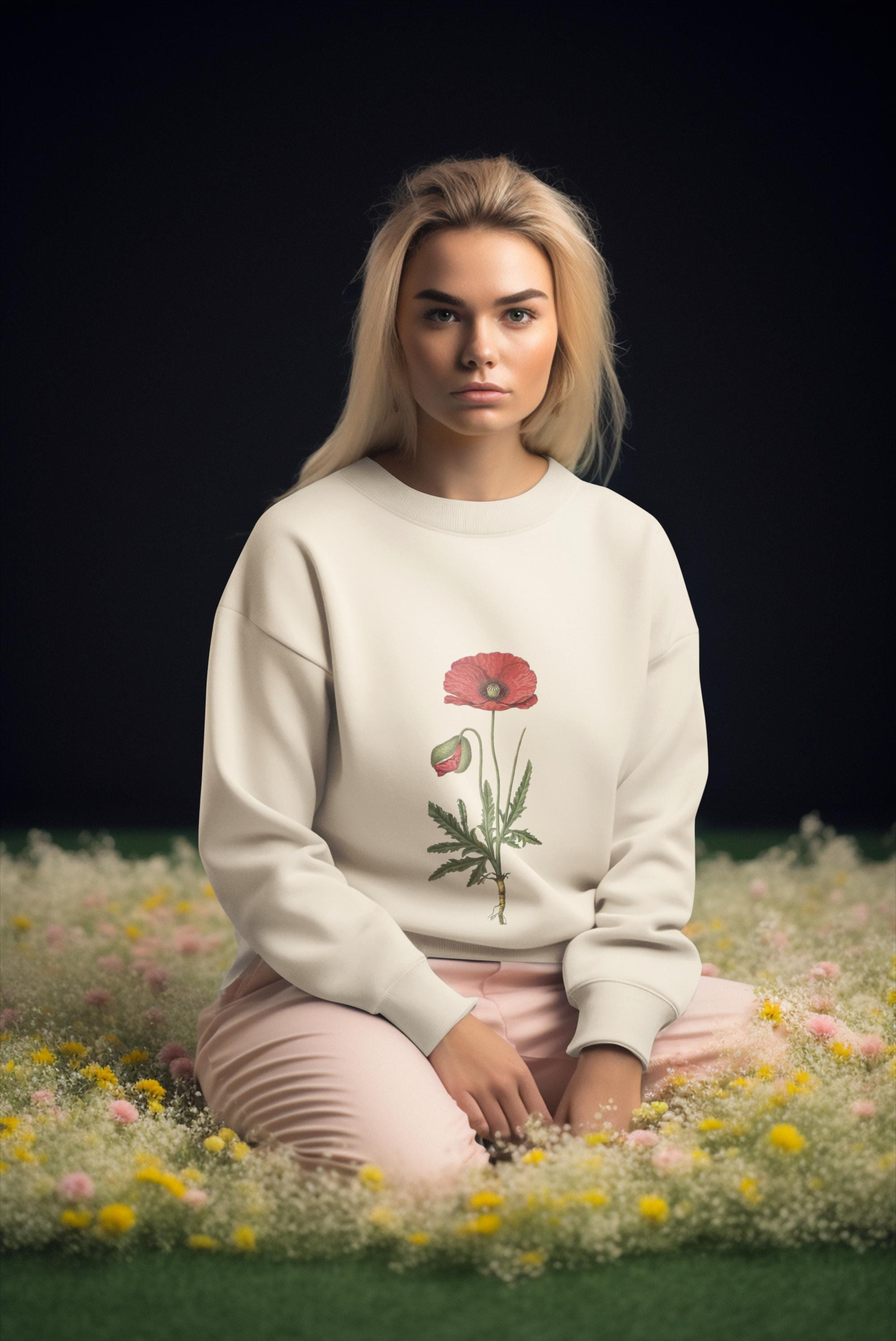 woman wearing cream crew neck sweatshirt with a red poppy on it