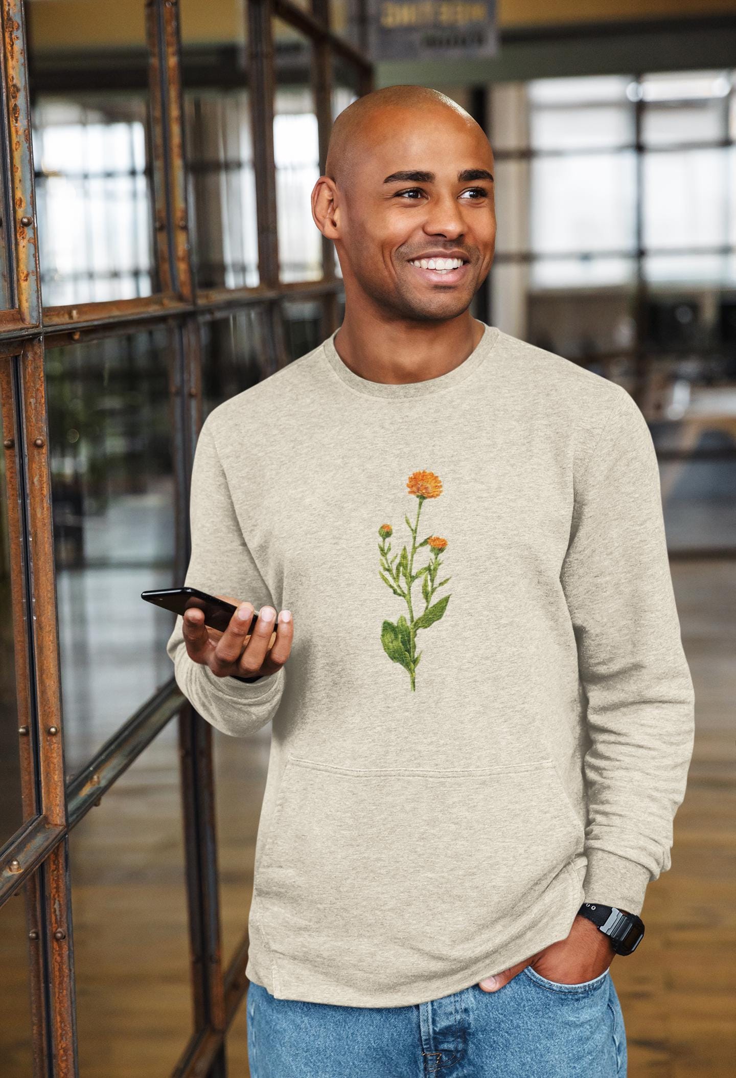 man swearing a cream colored crewneck sweatshirt with a calendula flower printed on it