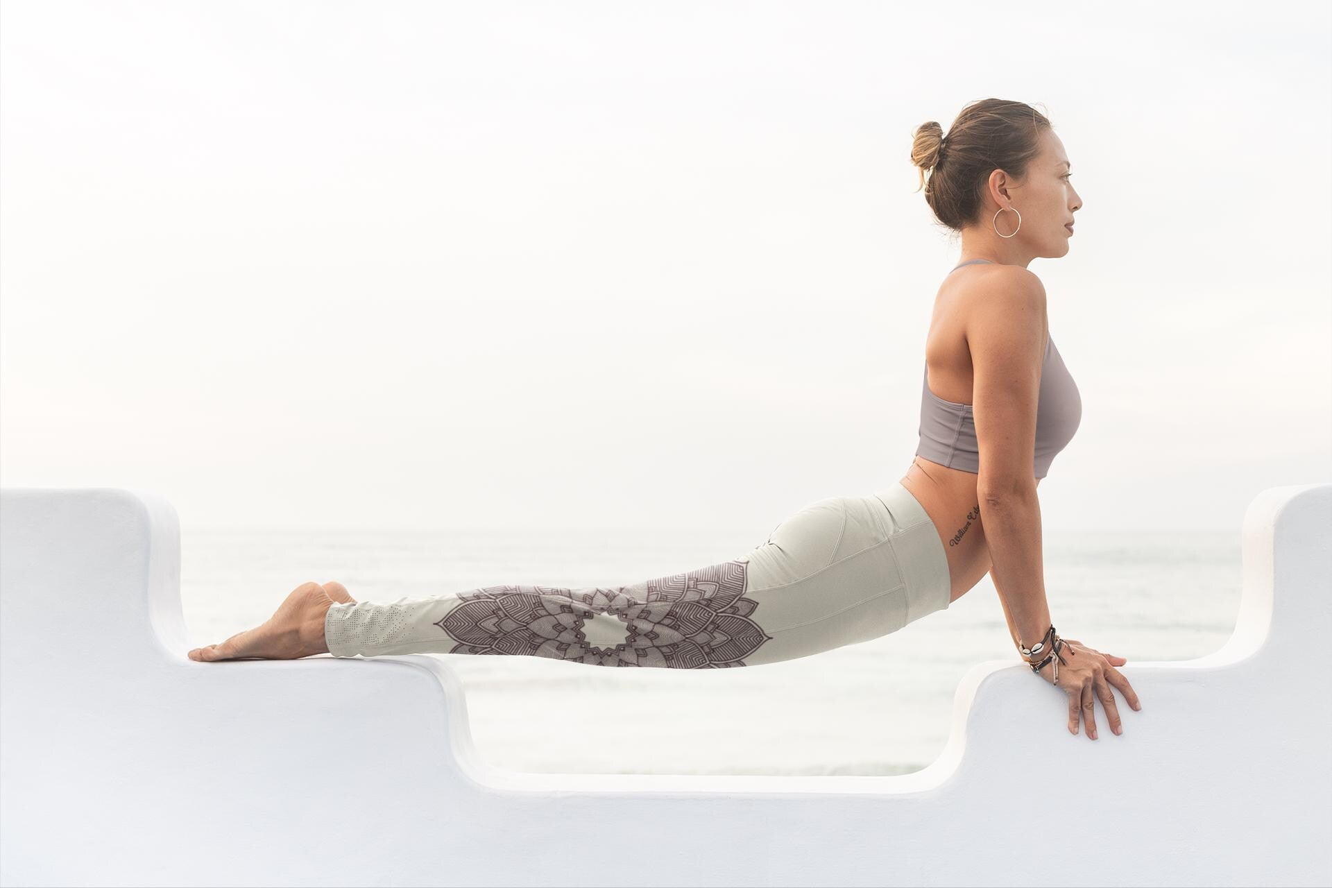 woman doing yoga and wearing coconut and cacao colored leggings with a lotus lace design on them