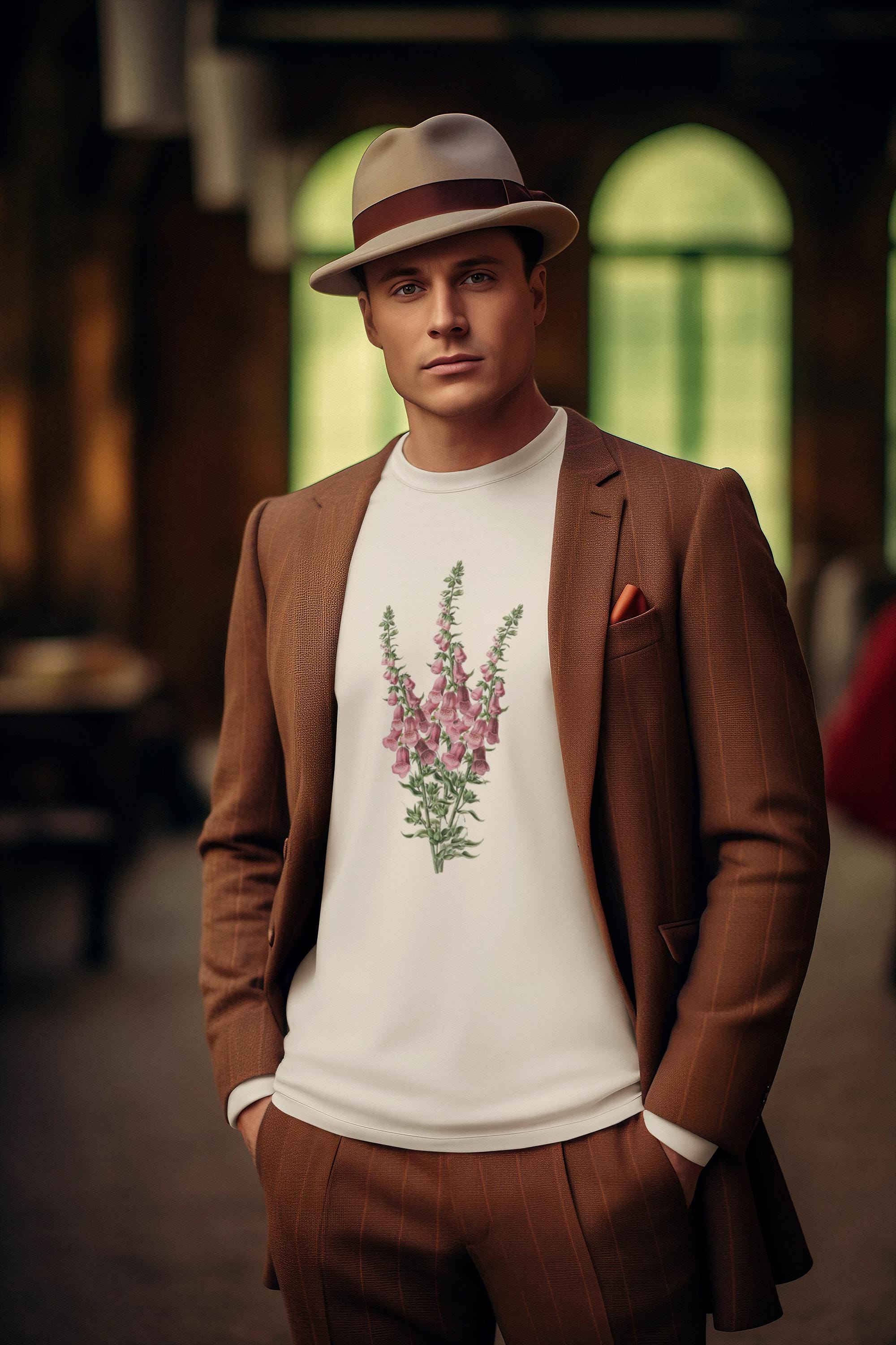 Man with beige hatl standing wearing a cream crewneck sweatshirt with a foxglove flower print on it and a brownout