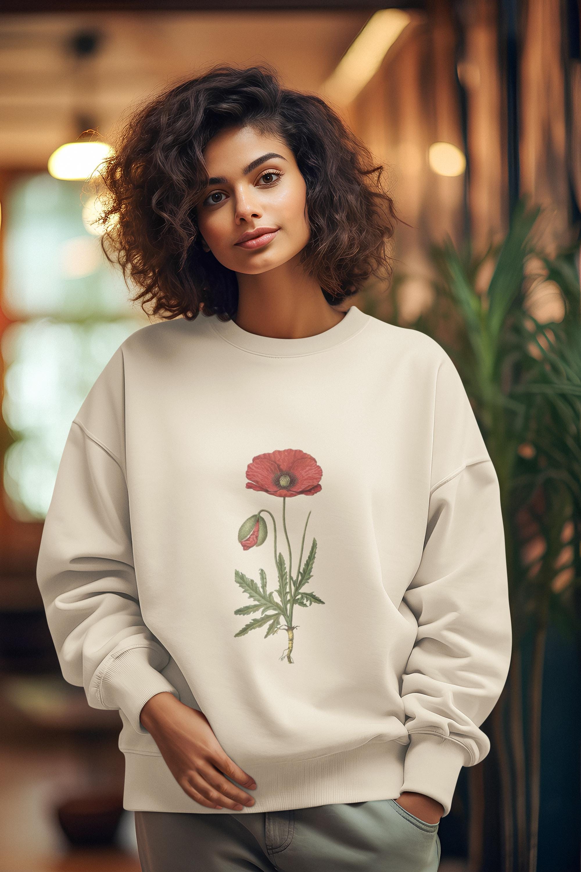 woman wearing cream crew neck sweatshirt with a red poppy on it