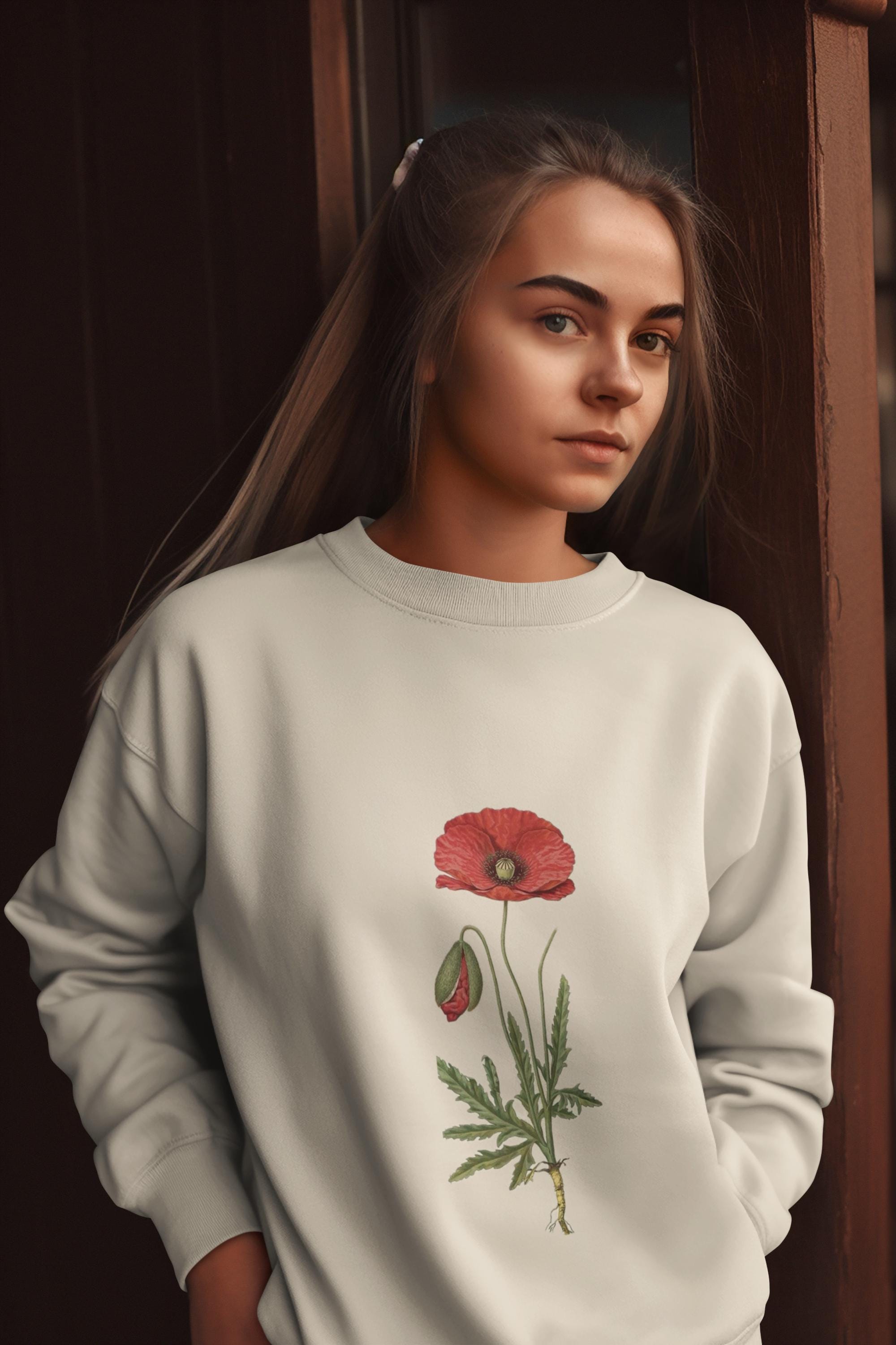 woman wearing cream crew neck sweatshirt with a red poppy on it