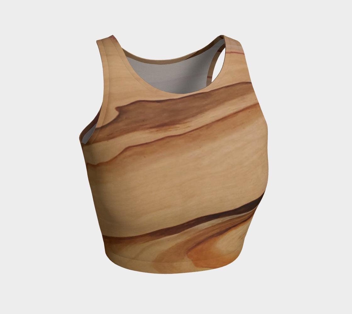 Yoga top in shades of brown blue and pink with a natural elemental design on them following the wood grain