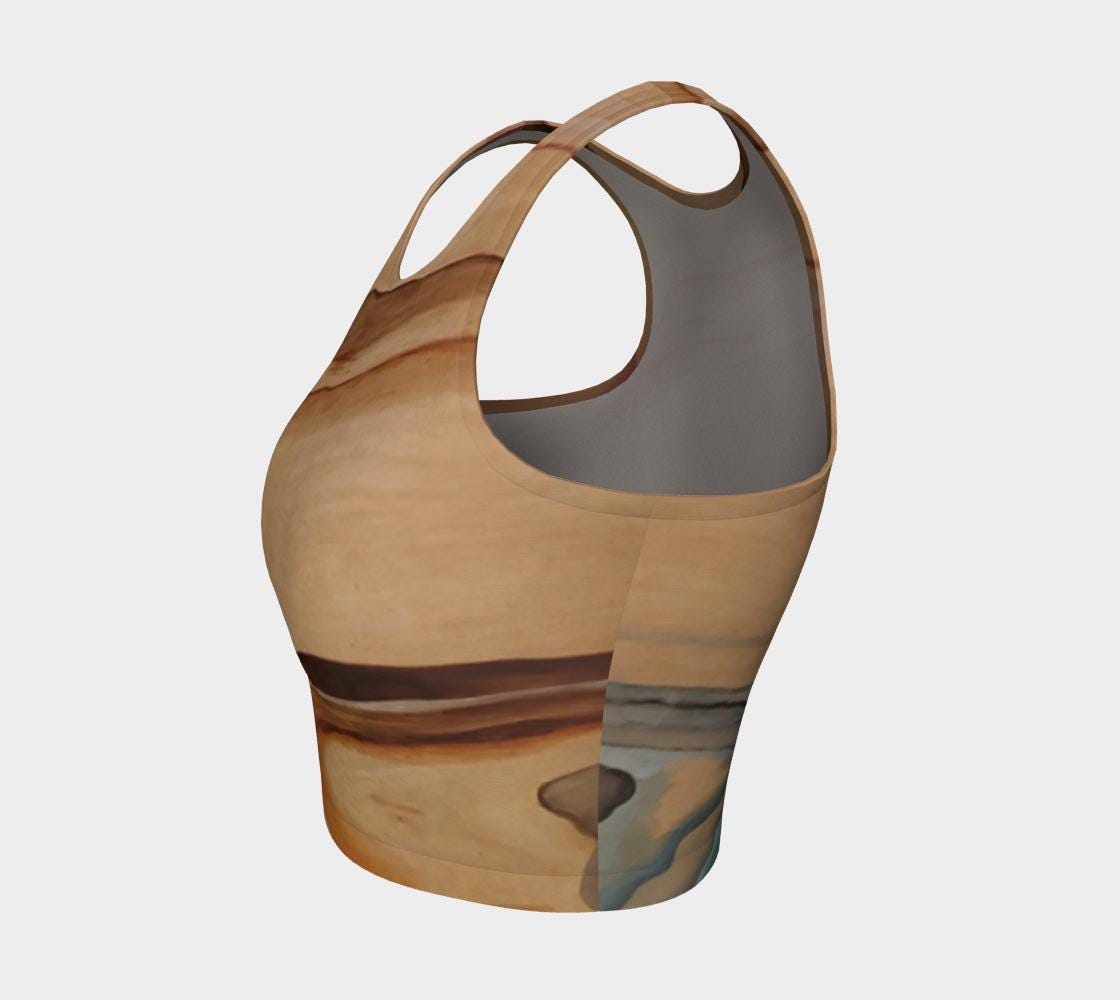 Yoga top in shades of brown blue and pink with a natural elemental design on them following the wood grain