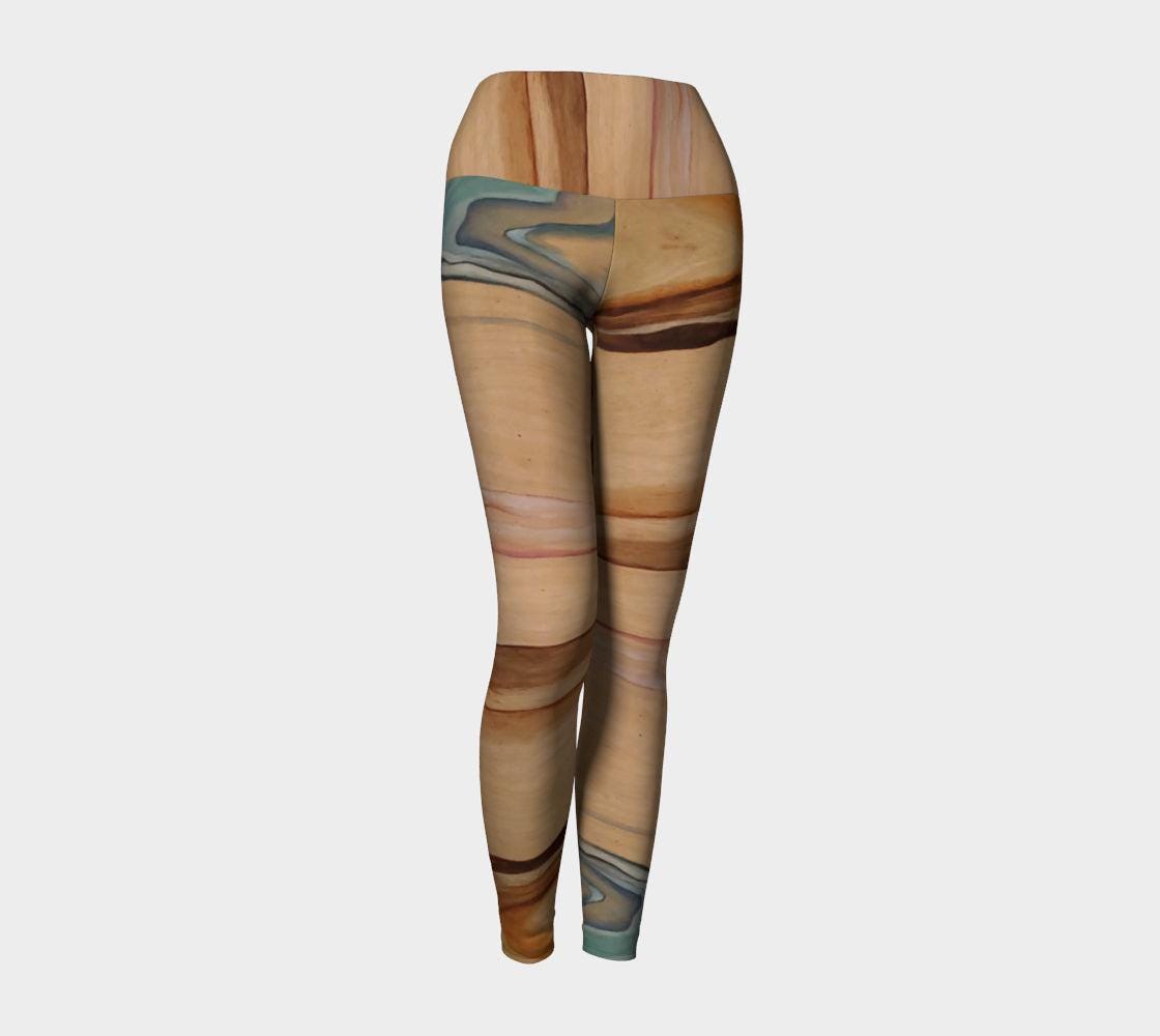 Yoga leggings in shades of brown blue and pink with a natural elemental design on them following the wood grain