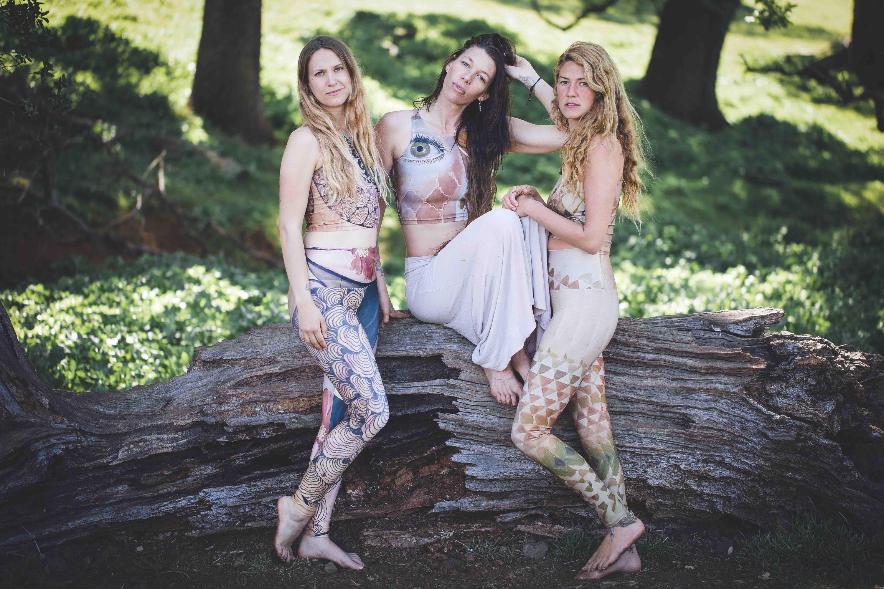 3 women in yoga sets in forest  in shades of pink and triangles