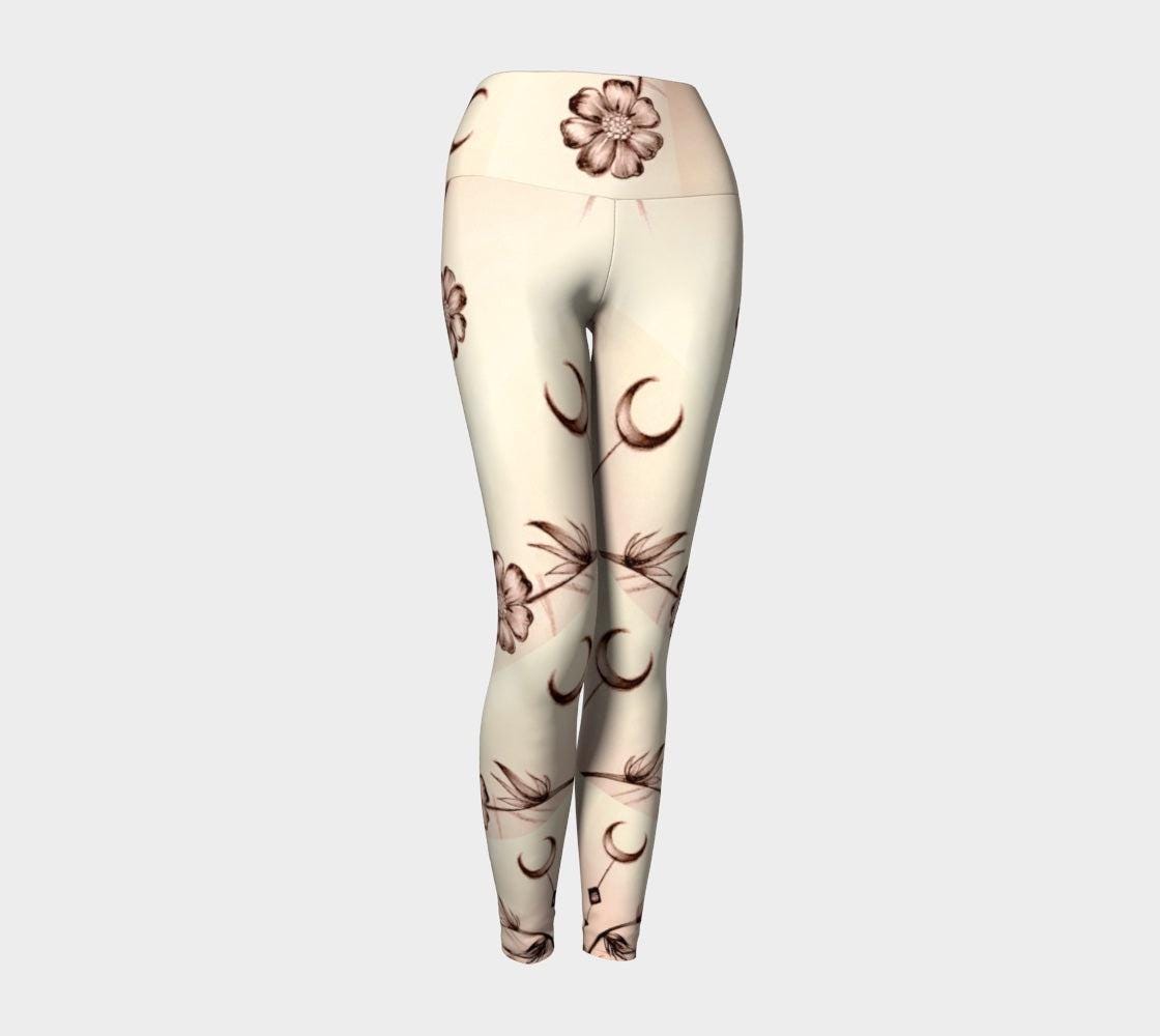 Yoga leggings in shades of white and cream with images of flowers and crescent moons drawn on them