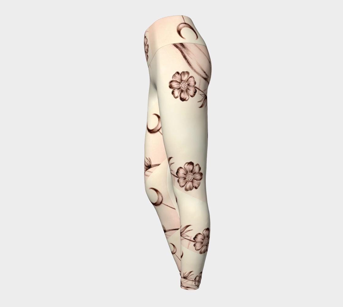 Yoga leggings in shades of white and cream with images of flowers and crescent moons drawn on them