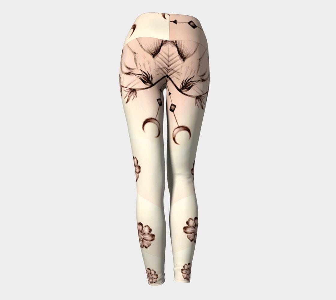 Yoga leggings in shades of white and cream with images of flowers and crescent moons drawn on them