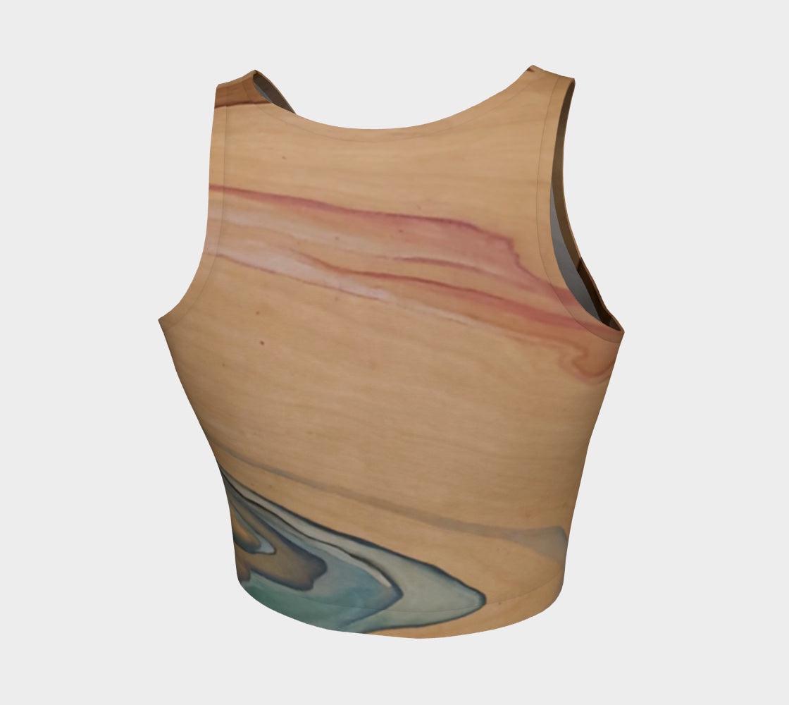 Yoga top in shades of brown blue and pink with a natural elemental design on them following the wood grain