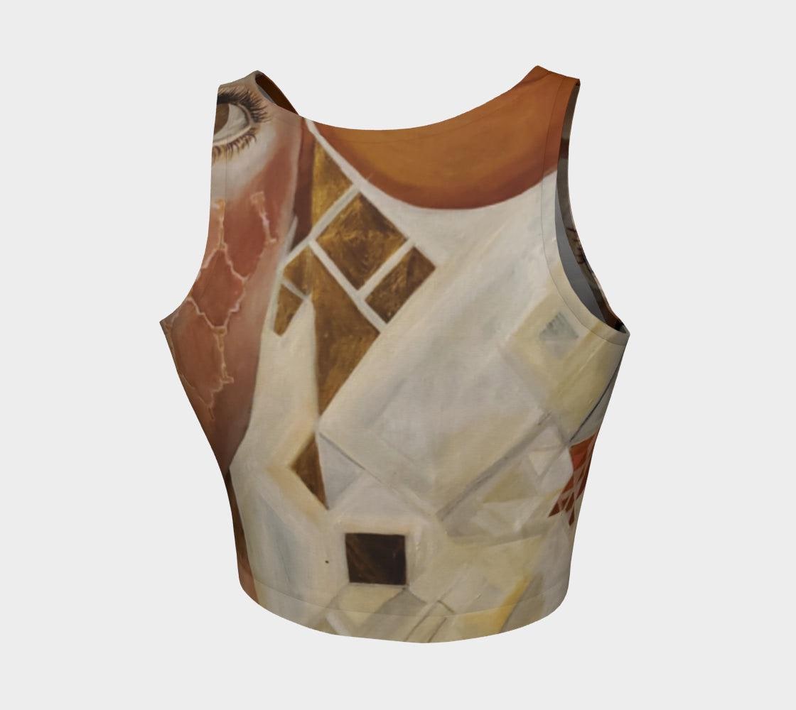 A crop top featuring a geometric pattern with diamonds in gold, black, and white, and wide open eyes on the front.