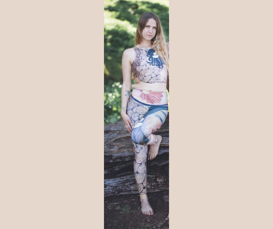 A person wearing a patterned yoga leggings with mushroom designs and floral patterns, featuring a goddess face motif at the top.