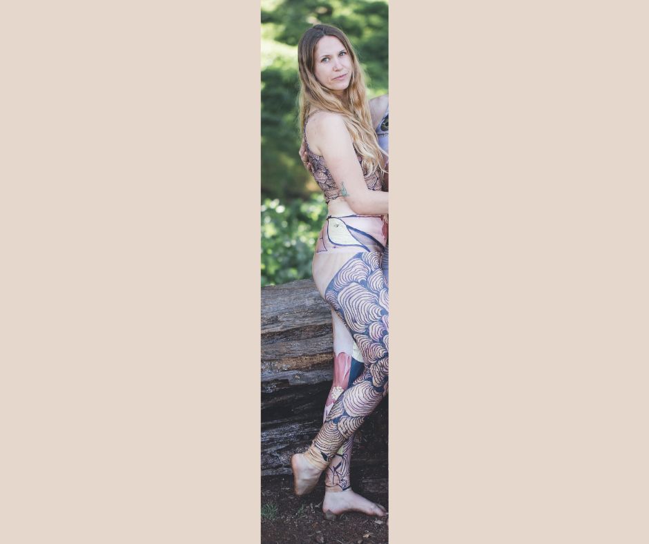 A person wearing a patterned yoga leggings with mushroom designs and floral patterns, featuring a goddess face motif at the top.