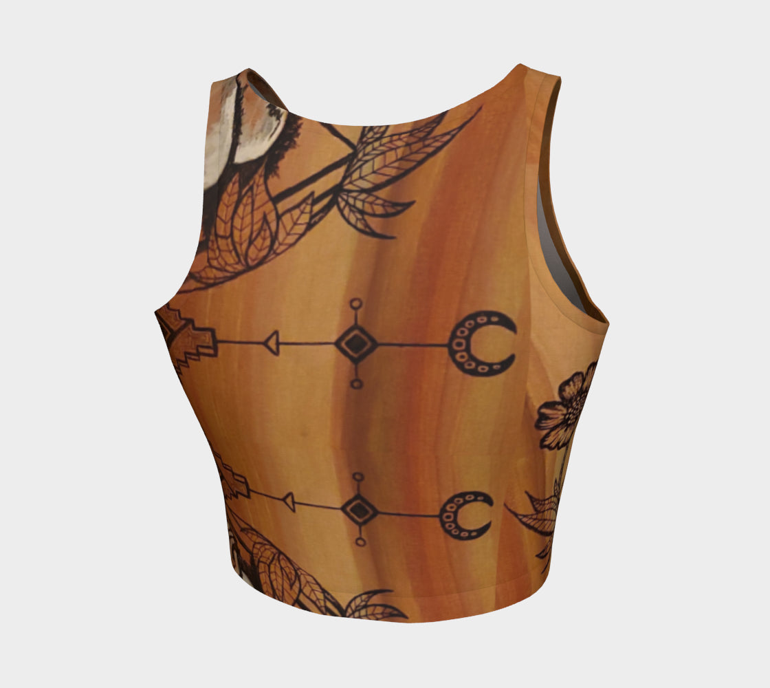 A cropped tank top with a floral leaf line and crescent moon designs on a golden brown background.